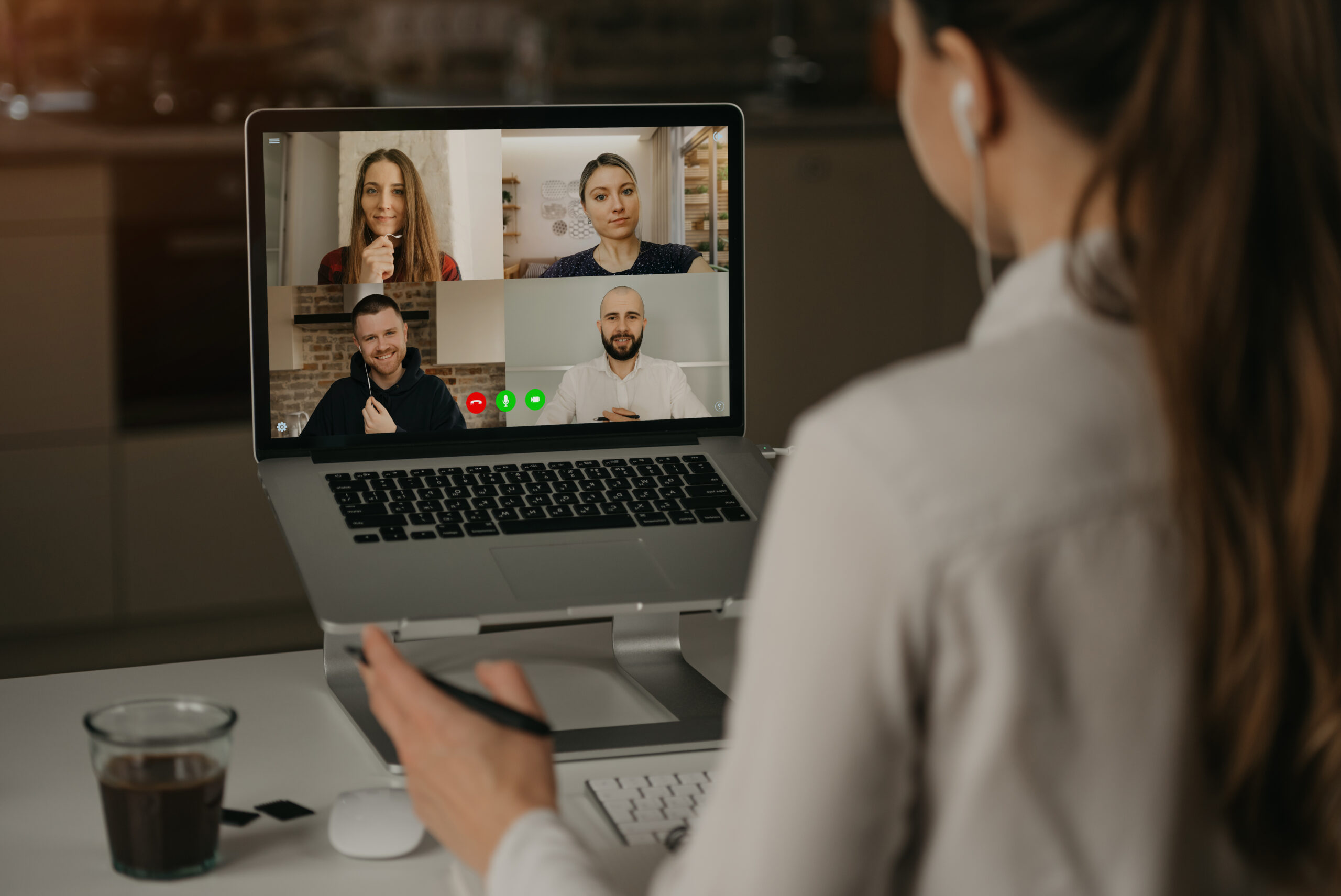 A Back view of a woman working remotely in a video conference wi